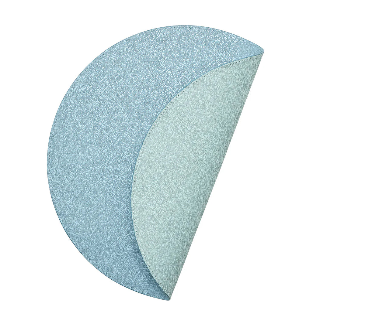 The Kim Seybert Icons Placemat Set of 4 features round, textured blue reversible placemats; each one curves to show a lighter blue underside and subtle shagreen texture.