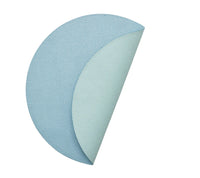 The Kim Seybert Icons Placemat Set of 4 features round, textured blue reversible placemats; each one curves to show a lighter blue underside and subtle shagreen texture.