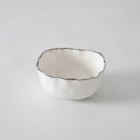 A small, white porcelain serving bowl with a wavy silver-edged rim, the PAMPA BAY Portofino Plata Bowl adds timeless elegance to your serveware collection as it sits beautifully on a plain white surface.