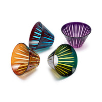 The Prism Condiment Bowls Set of 4 - Assorted by L'Objet features colored glassware bowls with vertical oval cutouts in blue, purple, orange, and green, each tilted at different angles on a white background.