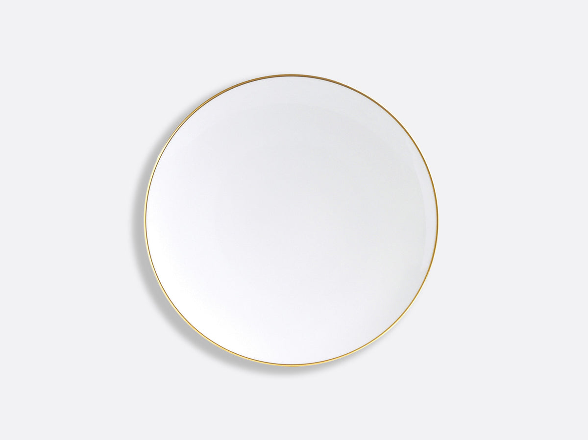 The Bernardaud Palmyre Dinnerware features a plain white round plate with a thin gold rim, set against a light gray background, offering an understated elegance to any refined table.
