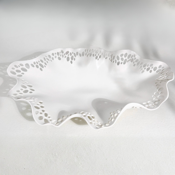 The Pierced Rim Bowl - White #20 by Kate Tremel is a white handmade ceramic bowl featuring a wavy, ruffled edge and decorative cutout holes along the border, displayed on a white surface.