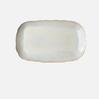 The Plume White Dinnerware Pearl by Jars - Rosenthal is a rectangular ceramic plate with gently scalloped edges and a light, speckled cream glaze, shown on a plain white background.