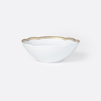 The Pompadour bowl by Bernardaud features white porcelain with gently scalloped edges and a delicate gold rim, reminiscent of classic Limoges dinnerware, shown against a plain light gray background.