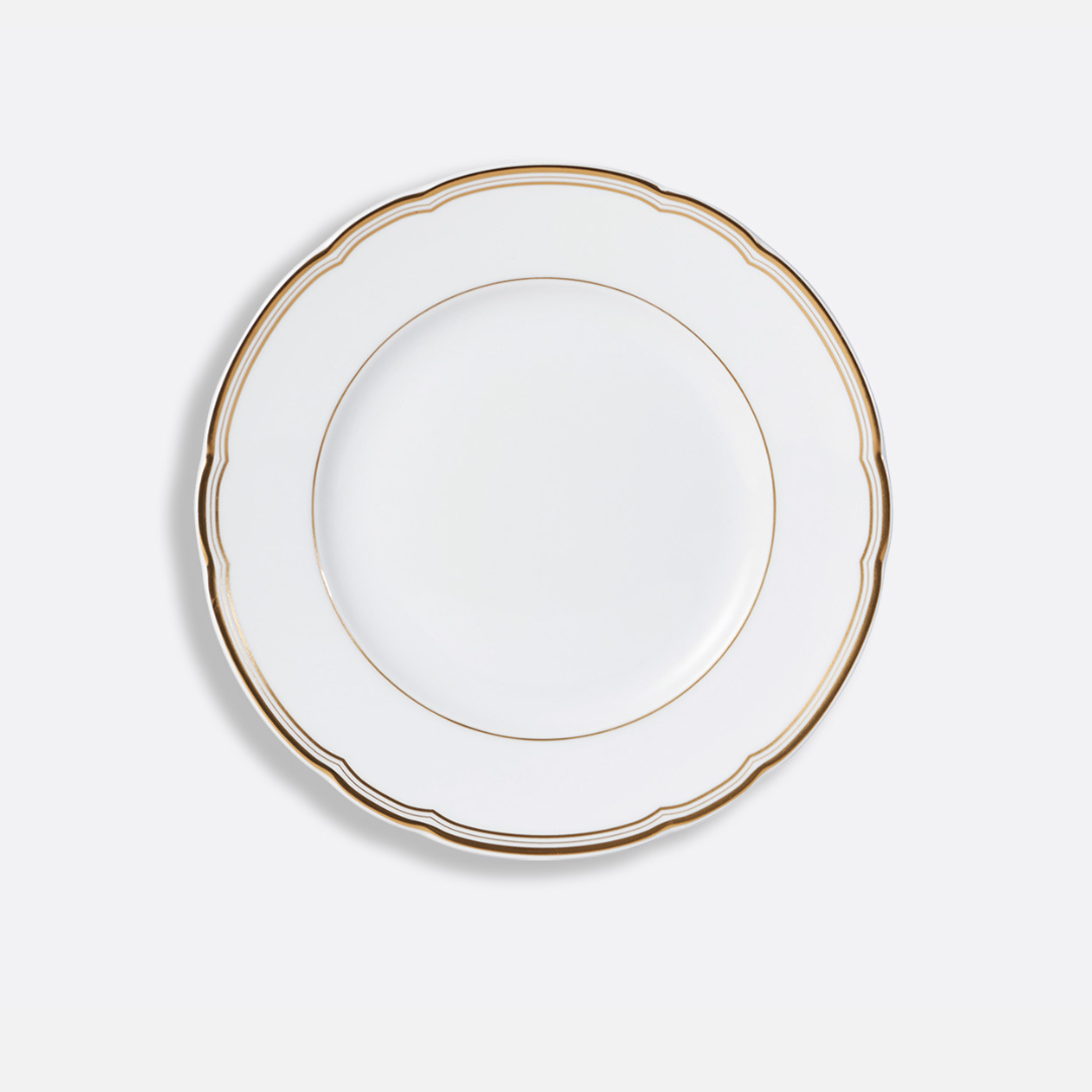 The Pompadour by Bernardaud is a white ceramic plate featuring a scalloped rim and gold trim, inspired by Limoges dinnerware, displayed against a white background.