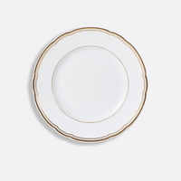 The Pompadour by Bernardaud is a white ceramic plate featuring a scalloped rim and gold trim, inspired by Limoges dinnerware, displayed against a white background.