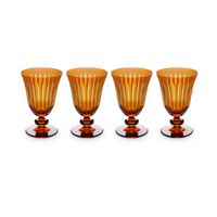 The Prism Wine Glass Set of 4 by L'Objet features amber hand-cut glass goblets with vertical ridges and rounded stems, arranged in a straight line against a white background, adding elegance to any collection.