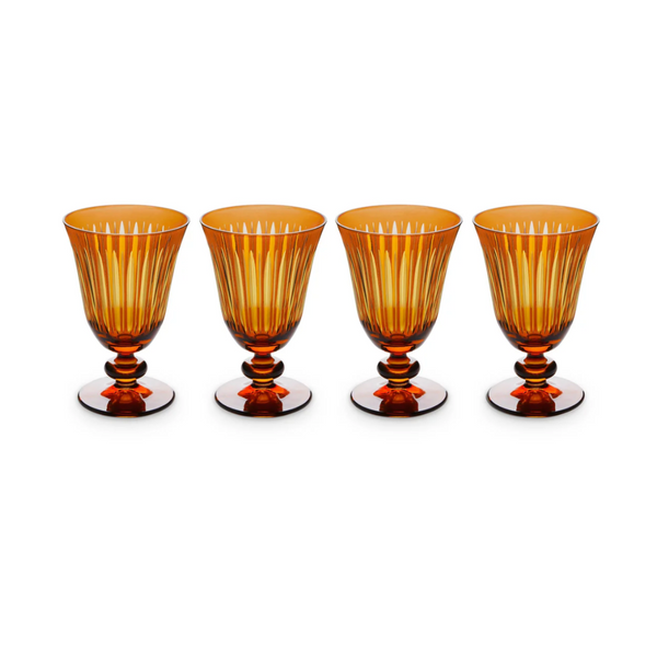 The Prism Wine Glass Set of 4 by L'Objet features amber hand-cut glass goblets with vertical ridges and rounded stems, arranged in a straight line against a white background, adding elegance to any collection.