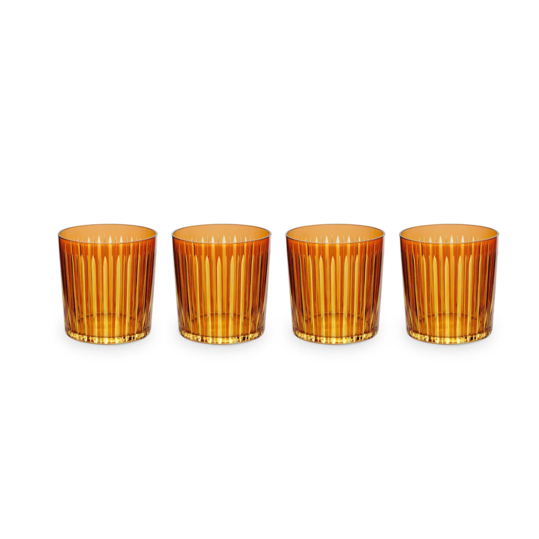 The Prism DOF Set of 4 by L'Objet features amber glass tumblers with vertical ribbed patterns, arranged in a row on a white background to highlight their exquisite design.