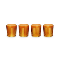 The Prism DOF Set of 4 by L'Objet features amber glass tumblers with vertical ribbed patterns, arranged in a row on a white background to highlight their exquisite design.