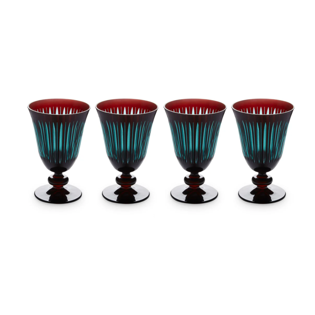 The Prism Wine Glass Set of 4 by L'Objet features elegant goblets with dark bases and stems, deep red interiors, and blue vertical stripes on clear hand-cut glass, all displayed in a row against a white background.
