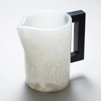The Pearl's Pitcher White with Charcoal Handle by Lily Juliet features a translucent white resin body, matte finish, wide spout, and large black handle. Perfect for serving drinks at dinner parties; shown against a light background.