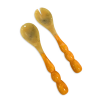 The Beatriz Ball Resin Rio Bubble Salad Servers include a horn spoon and fork with round, light brown bubble handles and beige translucent heads—perfect for serving salad in style.