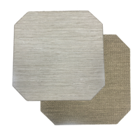 Two rectangular Julian Mejia Reversible Cut Corner Placemats from the Calia/Timber set are overlapping on a white background—one in light gray (Calia), the other in tan (Timber). Both feature a subtle striped texture and chamfered corners, accentuating their elegant design.