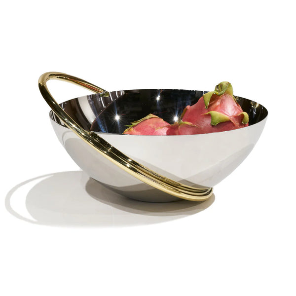 The Ring Fruit Bowl by Anna New York, featuring reflective stainless steel and a gold circular handle, holds two pink dragon fruits as a striking centerpiece on a plain white background.