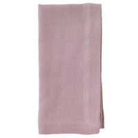 The Bodrum Riviera Napkin Set of 4 features rectangular, light mauve, stone-washed linen napkins with a subtle woven texture, neatly folded and displayed on a white background.