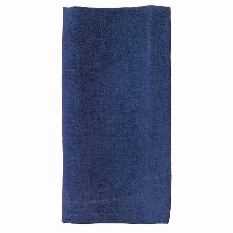 The Bodrum Riviera Napkin Set of 4 features neatly folded, rectangular dark blue stone-washed linen napkins displayed on a plain white background.