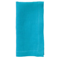 The Bodrum Riviera Napkin Set of 4 features neatly folded turquoise stone-washed linen napkins with visible edge stitching, shown on a white background.