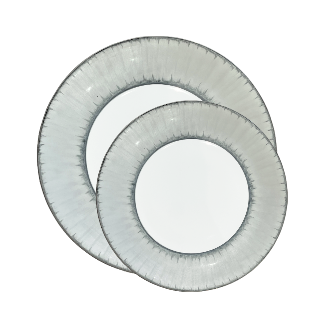 Two round, white plates with translucent, textured gray rims overlap each other against a plain white background, showcasing the refined artistry of Marie Daâge Ruban Dinnerware Platinum Rim by Marie Daâge.