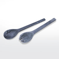 The Swirl Resin Classic Everyday Salad Server Set by Nashi Home features two handcrafted servers—one spoon and one forked spork—in dark gray resin with a marbled texture and modern, minimalist design, shown on a white background.