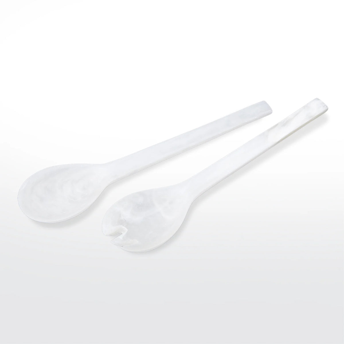 The Nashi Home Swirl Resin Classic Everyday Salad Server Set features two white, marble-patterned resin servers—one spoon and one forked—with elongated handles. Handcrafted and BPA free, they're stylish serveware essentials.