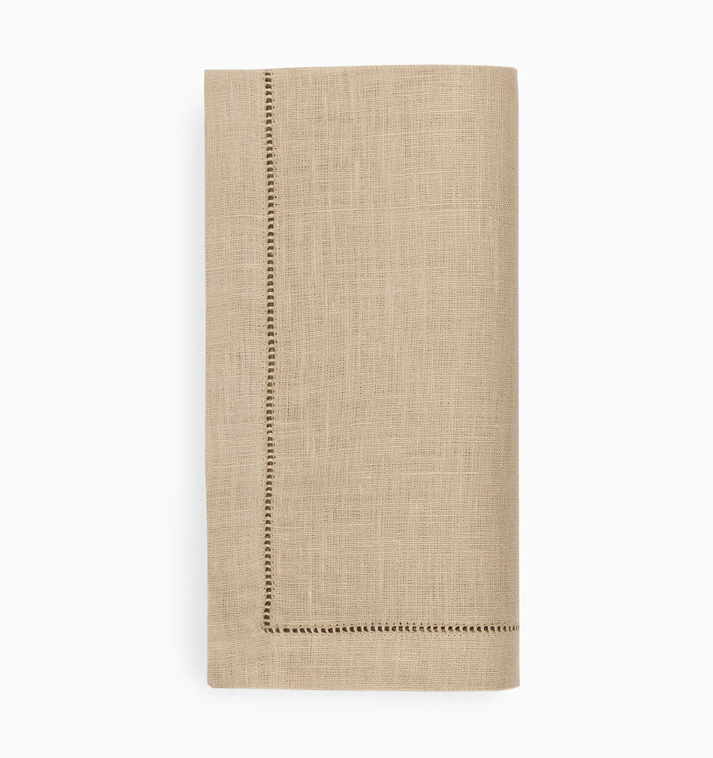 The Sferra Festival Napkin Set of 4 features neatly folded beige European linen napkins with decorative stitched borders, displayed on a plain white background.