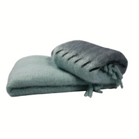 Two luxurious Mantas Ezcaray Stitching Throws, in light blue and gray—one with fringe and stitched details—are displayed on a plain white background. Each mohair blanket is expertly handmade in Ezcaray.