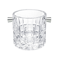 The Manhattan Ice Bucket by Saint-Louis/Hermes features clear, intricately cut crystal and two silver handles, making it an elegant addition to your bar setup, shown against a white background.