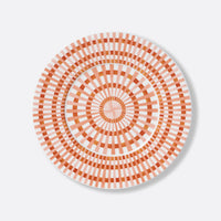 The Terra Rosa Dinnerware by Bernardaud features a round plate with orange and white geometric concentric circles and radiating lines for a striking sunburst effect. Made in Limoges, France.