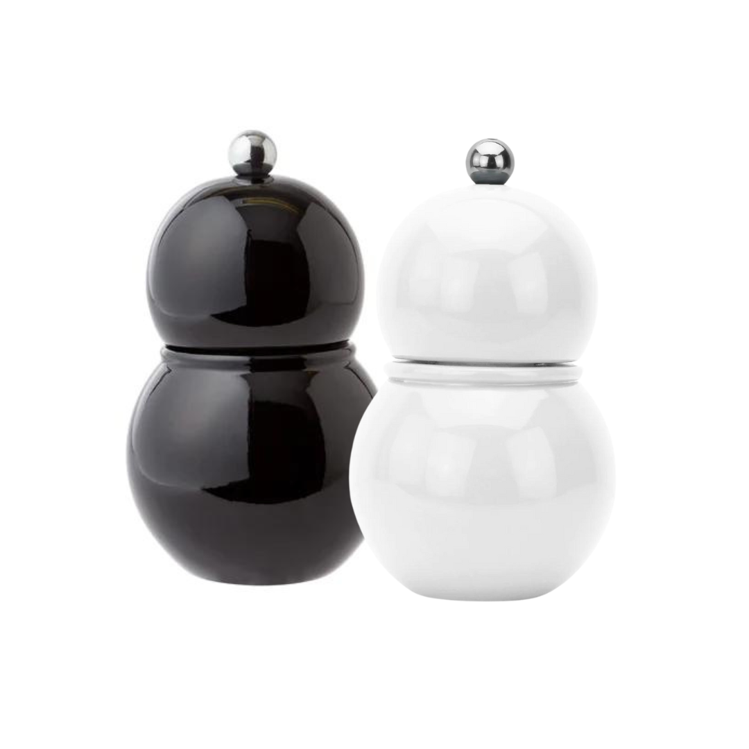 Two round Chubbie Bobbin Salt or Pepper Shakers by Addison Ross, in black and white high gloss lacquer with metallic knobs, stand side by side like modern shakers against a plain white background.