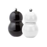 Two round Chubbie Bobbin Salt or Pepper Shakers by Addison Ross, in black and white high gloss lacquer with metallic knobs, stand side by side like modern shakers against a plain white background.