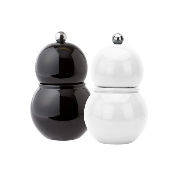 Two round Chubbie Bobbin Salt or Pepper Shakers by Addison Ross, in black and white high gloss lacquer with metallic knobs, stand side by side like modern shakers against a plain white background.