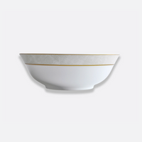 The Bernardaud Sauvage Gold Dinnerware features a white Limoges porcelain bowl with a delicate embossed snakeskin pattern and a slender gold rim, showcased against a simple light background.