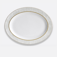 The Bernardaud Sauvage Gold Dinnerware is a white, round Limoges porcelain plate featuring a textured snake skin embossed rim and a fine gold band, displayed on a plain light background.