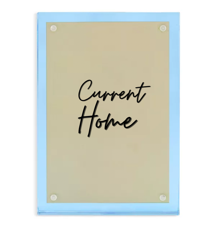 The Tizo Lucite Magnetic Frame Blue features a rectangular gold-colored acrylic sign with rounded corners, light blue edges, and "Current Home" in black cursive at the center, held by four round magnetic fixtures.
