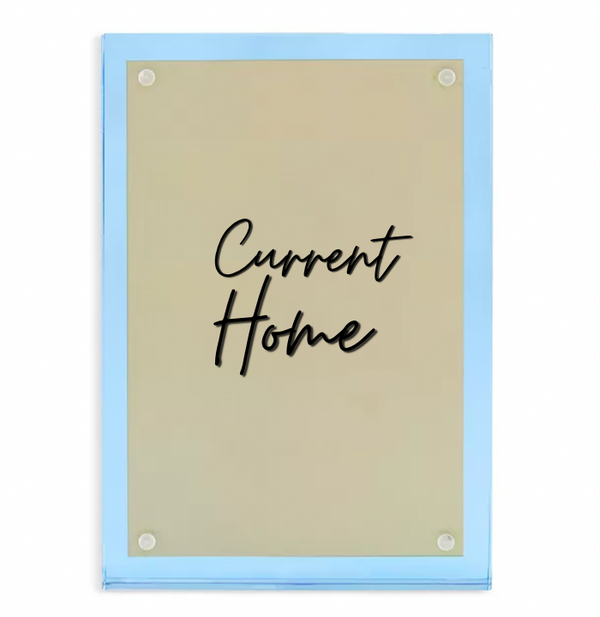 The Tizo Lucite Magnetic Frame Blue features a rectangular gold-colored acrylic sign with rounded corners, light blue edges, and "Current Home" in black cursive at the center, held by four round magnetic fixtures.