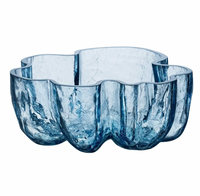 The Crackle Bowl Blue by Orrefors Kosta Boda features transparent blue crackle glass with a wavy, organic rim and a textured surface that evokes delicate petals or gentle waves.