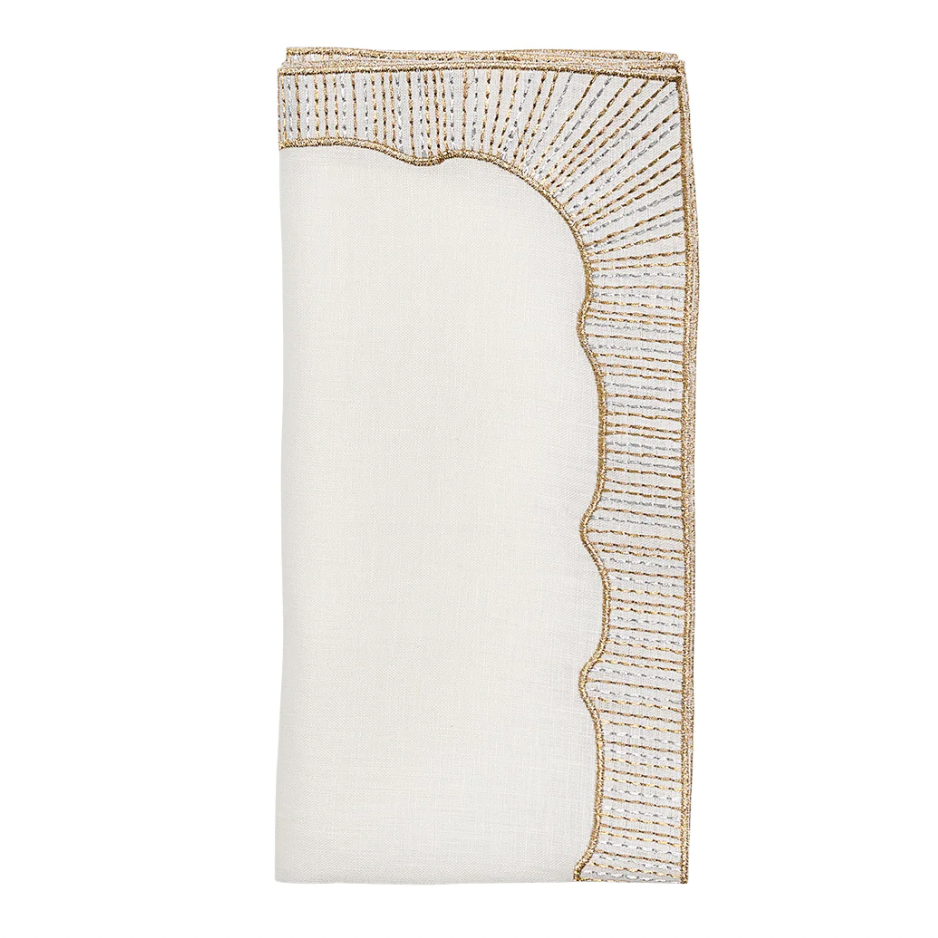 The Frame White, Gold & Silver Napkin Set of 4 by Kim Seybert features folded white linen napkins with scalloped edges and intricate gold and silver embroidery—ideal for sophisticated, elegant table settings.