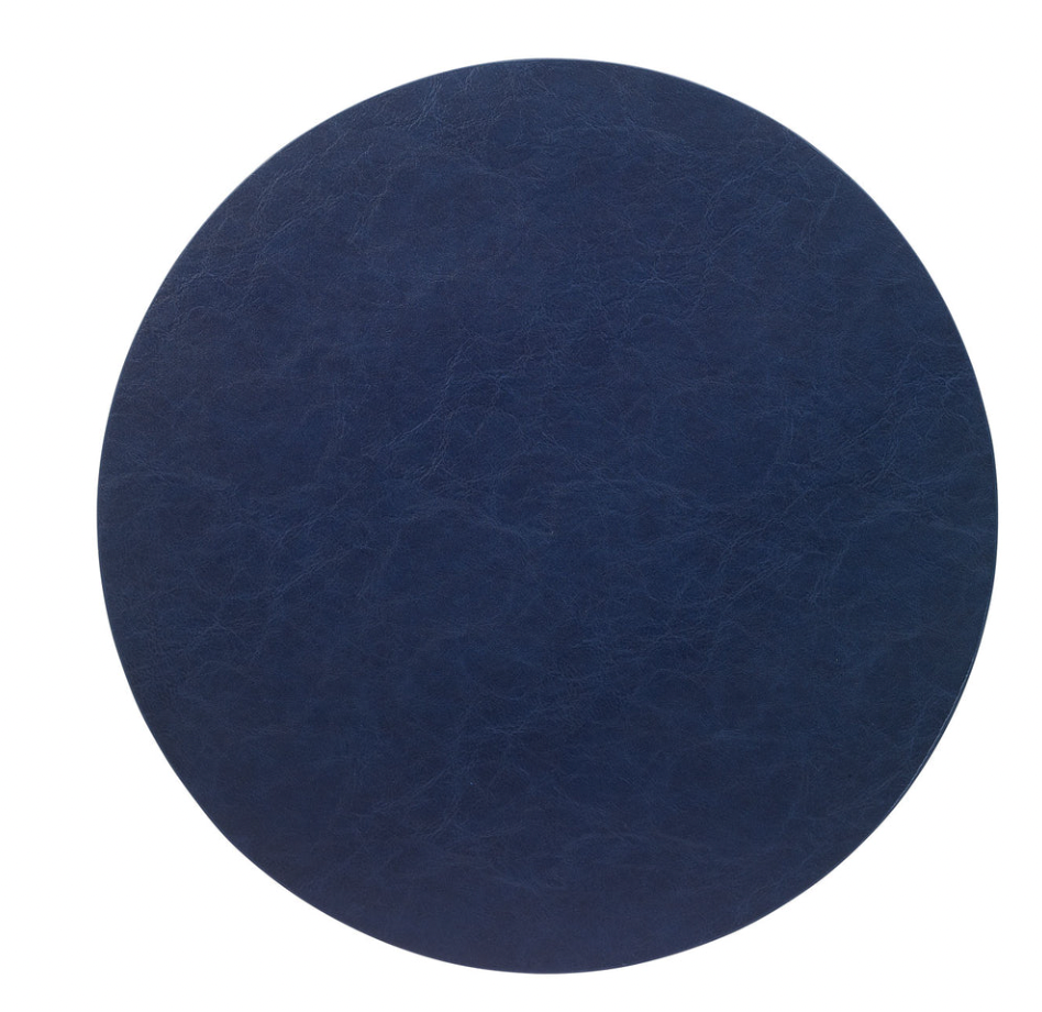 A round, dark blue vegan leather placemat with a textured finish, photographed on a white background—stylish and easy to care for.