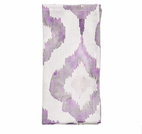 The Kim Seybert Watercolor Ikat Napkin Lilac & Grey Set of 4 features neatly folded white linen napkins with a stylish purple and gray watercolor Ikat pattern for an artistic touch.