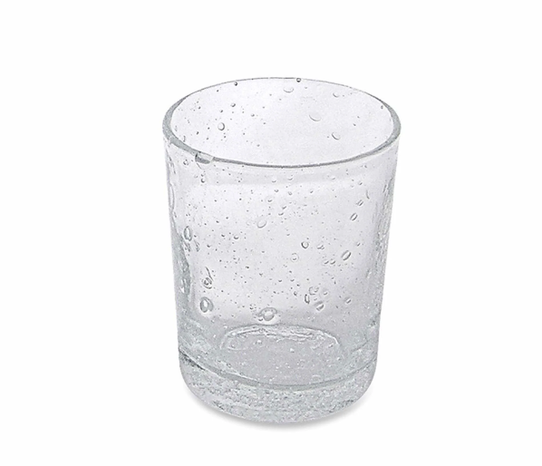 A clear stemless Bellini Glassware by Mariposa, featuring small air bubbles throughout its surface, stands empty on a white background. This elegant Italian glass is dishwasher safe.