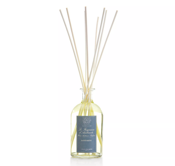 The Antica Farmacista/Harper Santorini Diffuser features a glass bottle labeled "Santorini" with long reeds, set against a white background, infusing your space with an elegant Mediterranean-inspired fragrance.