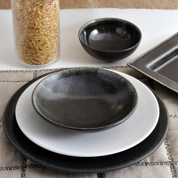 The Tourron Dinnerware Celeste by Jars - Rosenthal features two plates, a shallow bowl, and a small bowl in black and white tones. These elegant glazed stoneware pieces are dishwasher safe and beautifully displayed beside a jar of mixed rice.