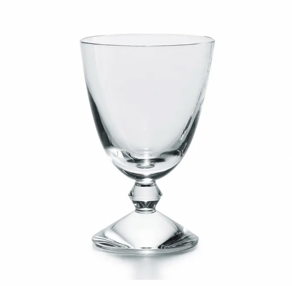 The Baccarat Vega Water Glass features a clear, wide-bowled goblet artfully set on an inverted glass base, standing out as a luxurious and unique piece—ideal for those who appreciate fine glassware.