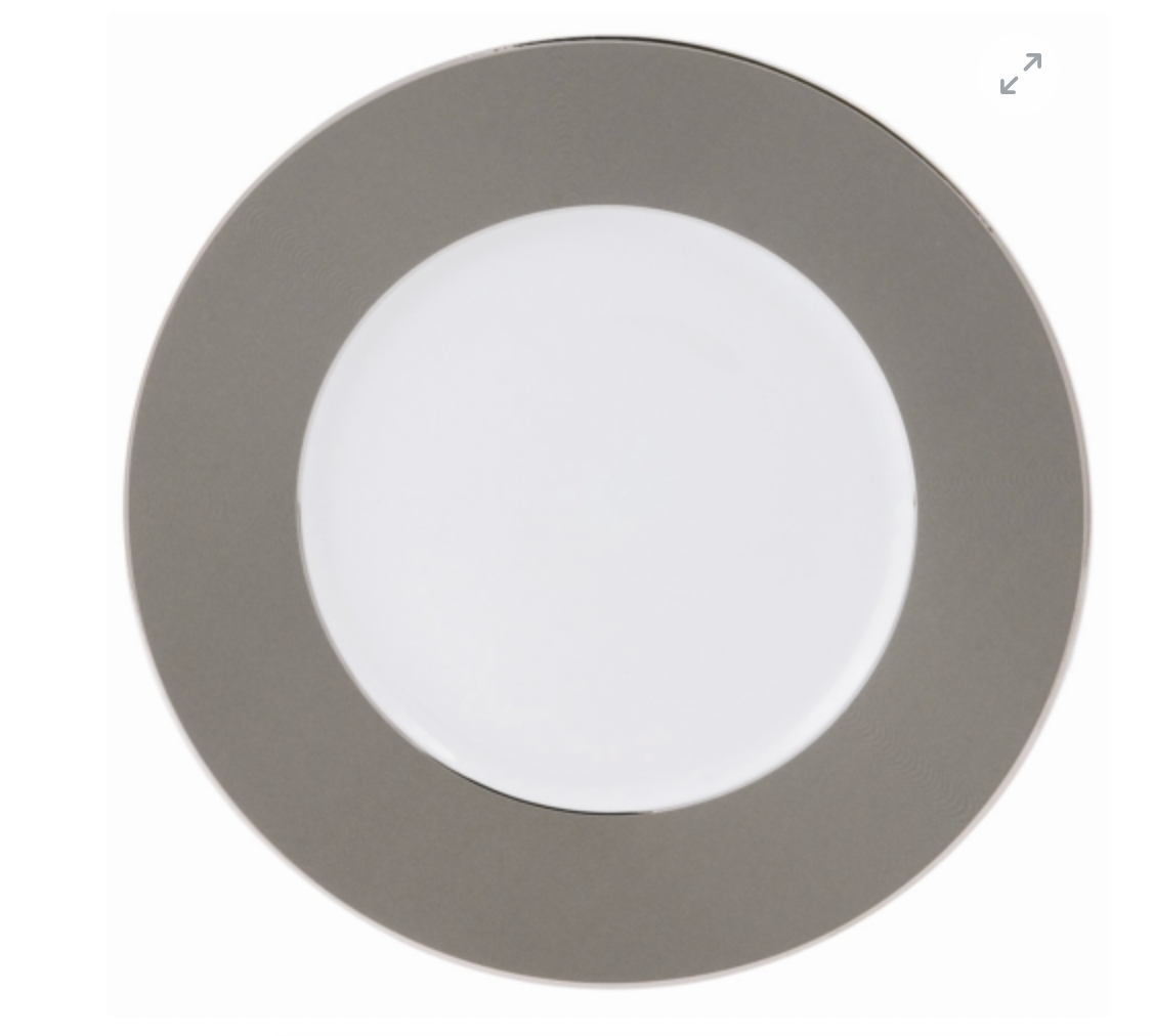 The Philippe Deshoulieres BIA Metallic Presentation Plate is round with a wide metallic gray rim and plain white center, accented by subtle platinum details and shown from above on a white background.