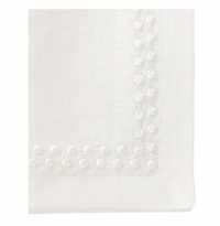 Close-up of a Bodrum Pearls Napkin White Set of 4, crafted from fine linen with a textured dotted border reminiscent of embroidered edges on a smooth, clean surface.