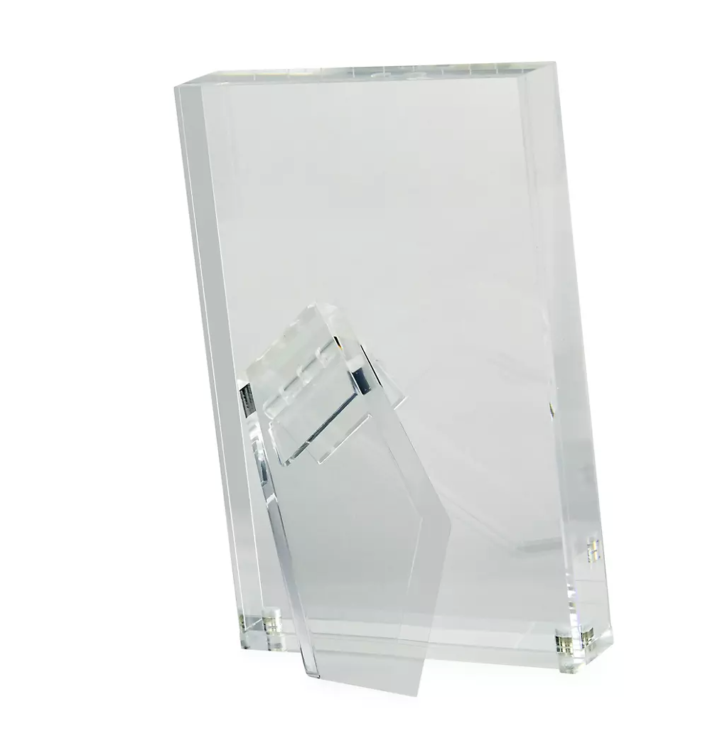 The Tizo Lucite Clear Frame features a minimalist, modern design with an upright clear acrylic build and angled rectangular base. This sleek frame currently displays no visible photo inside.
