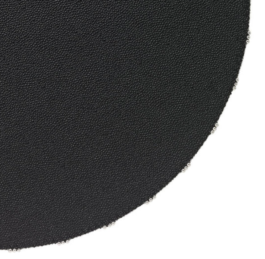 Close-up of Bodrum's Charm Placemat Black Set of 4, showing round black placemats with evenly spaced metal rings along the edge, against a white background.