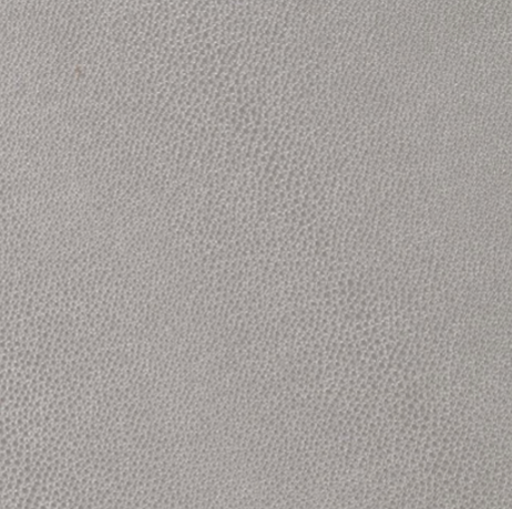 Close-up of Bodrum’s Skate Round Placemat Grey (Set of 4), featuring a light gray, subtly textured surface with a uniform dot pattern, resembling soft fabric or phthalate-free vinyl.