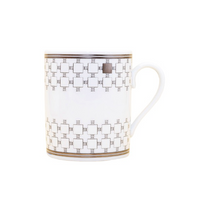 The Home Platinum Dinnerware mug by Robert Haviland & C. Parlon is a white ceramic piece with gold geometric squares, a curved handle, and gold bands at the rim and base—an elegant addition to any luxury tableware collection.